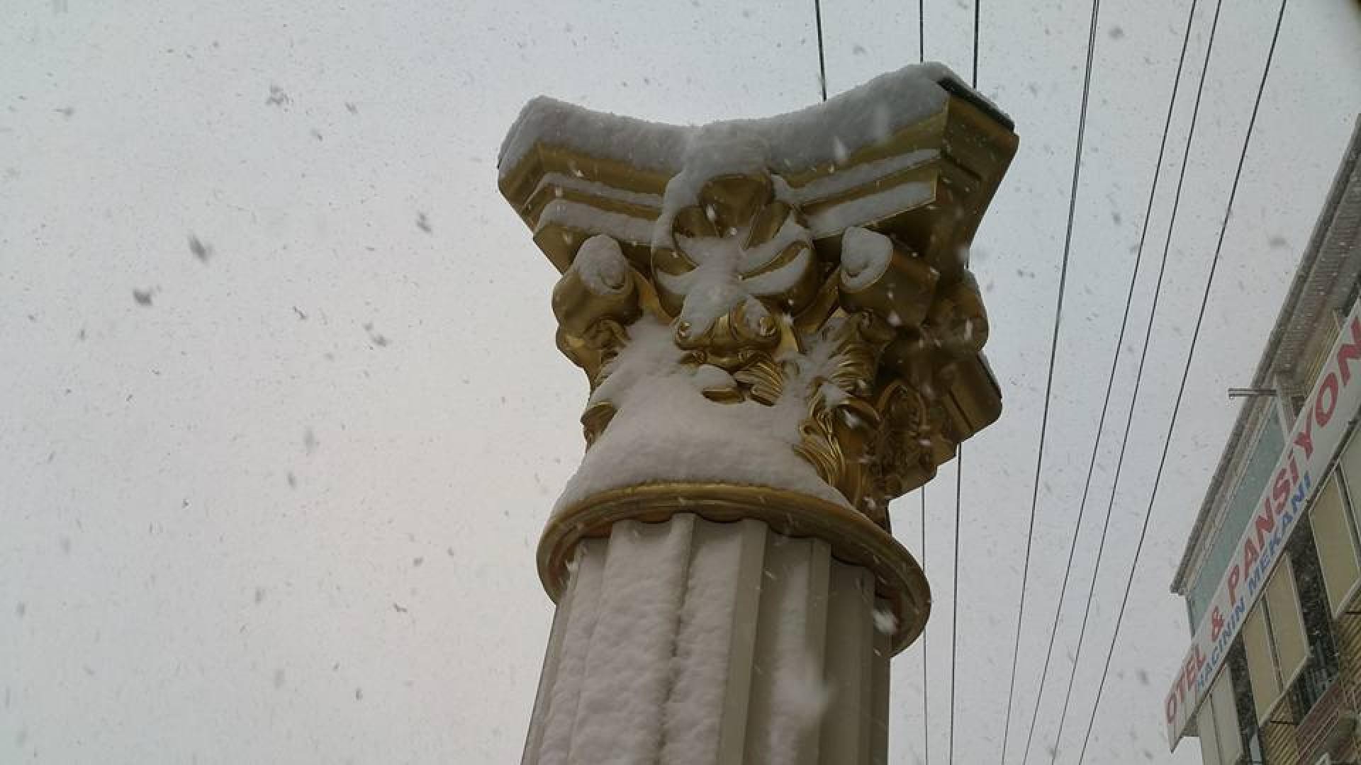 Capitel auriu de coloană decorativă de exterior acoperit parțial de zăpadă