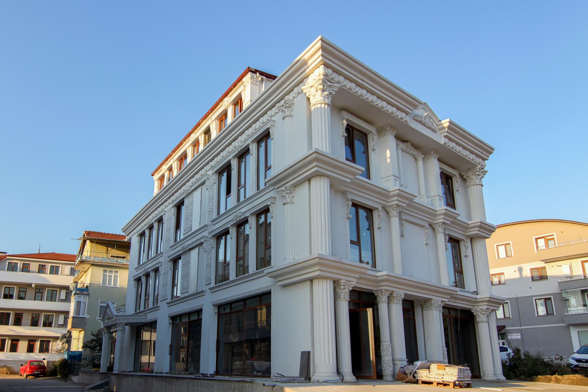 Clădire de colț neoclasică albă cu coloane corintice canelate din poliuretan