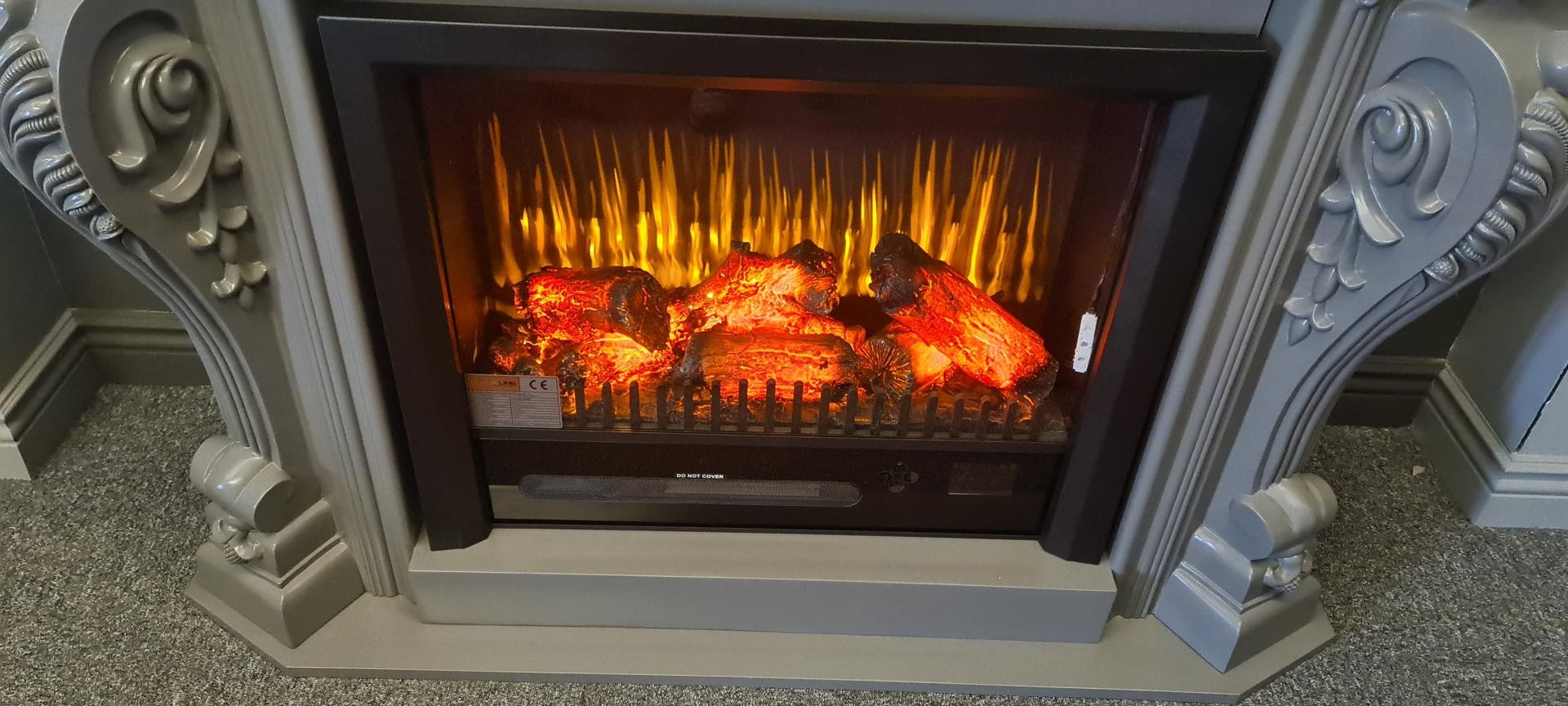 Prim-plan cu semișemineu gri, foc electric și console sculptate din poliuretan