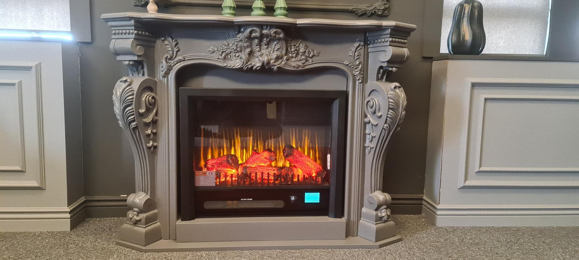 Semișemineu gri cu ornament central sculptat și pilaștri cu volute, foc electric aprins