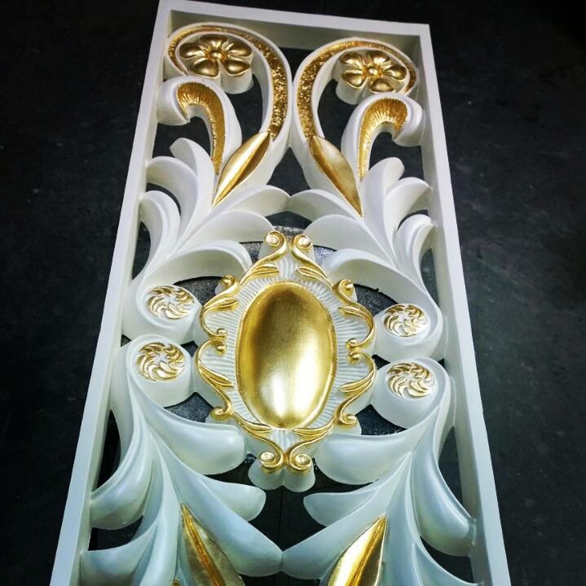 Panou decorativ vertical alb cu volute, cartuș oval și accente aurite, văzut de sus