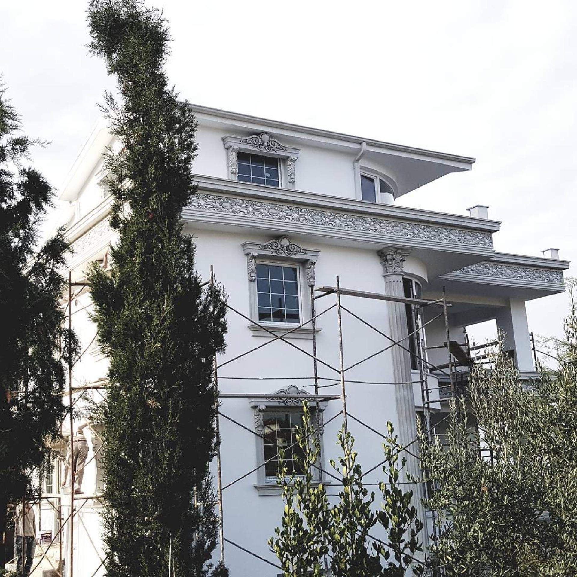Fatada de vila alba cu schele, ancadramente de ferestre si brau decorativ