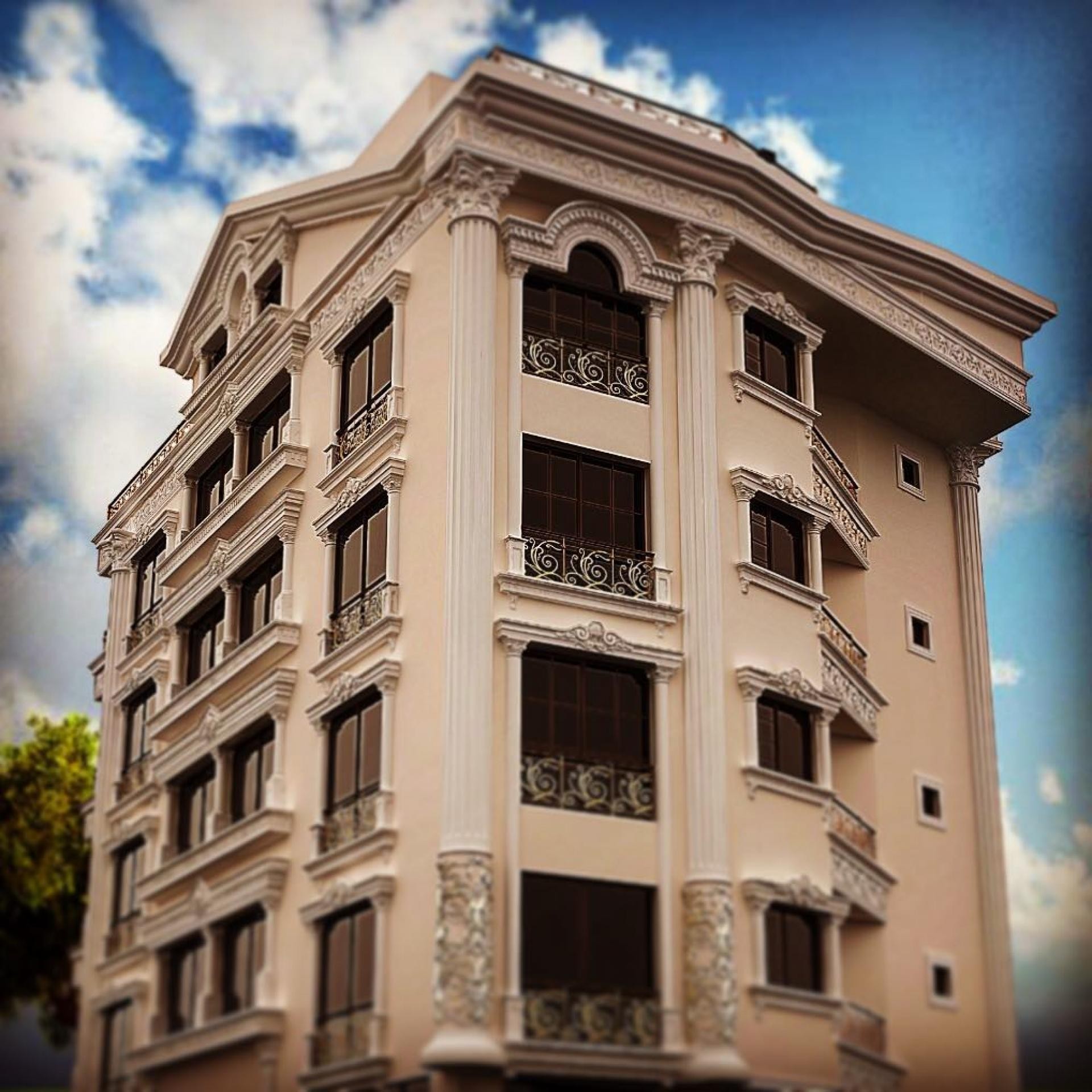 Fatada de bloc neoclasic crem cu pilastri canelati si balcoane din fier forjat