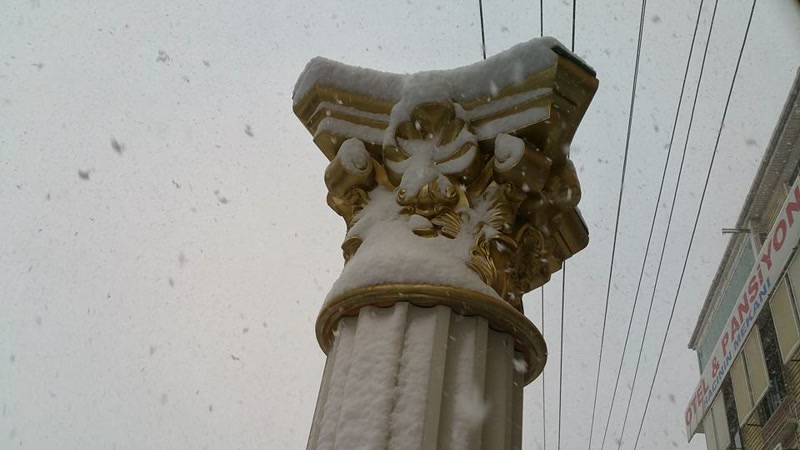 Coloană decorativă de exterior cu capitel auriu sub zăpadă