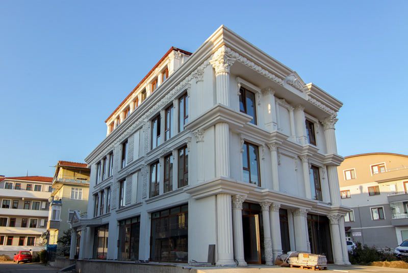 Clădire de colț neoclasică albă cu coloane corintice canelate din poliuretan