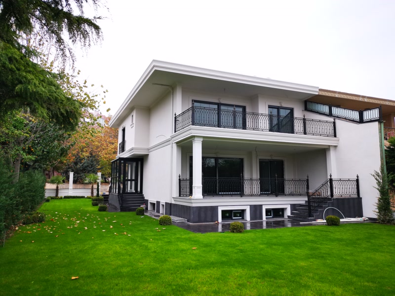 Fațadă de vilă modernă cu cornișă și balcoane cu balustradă fier