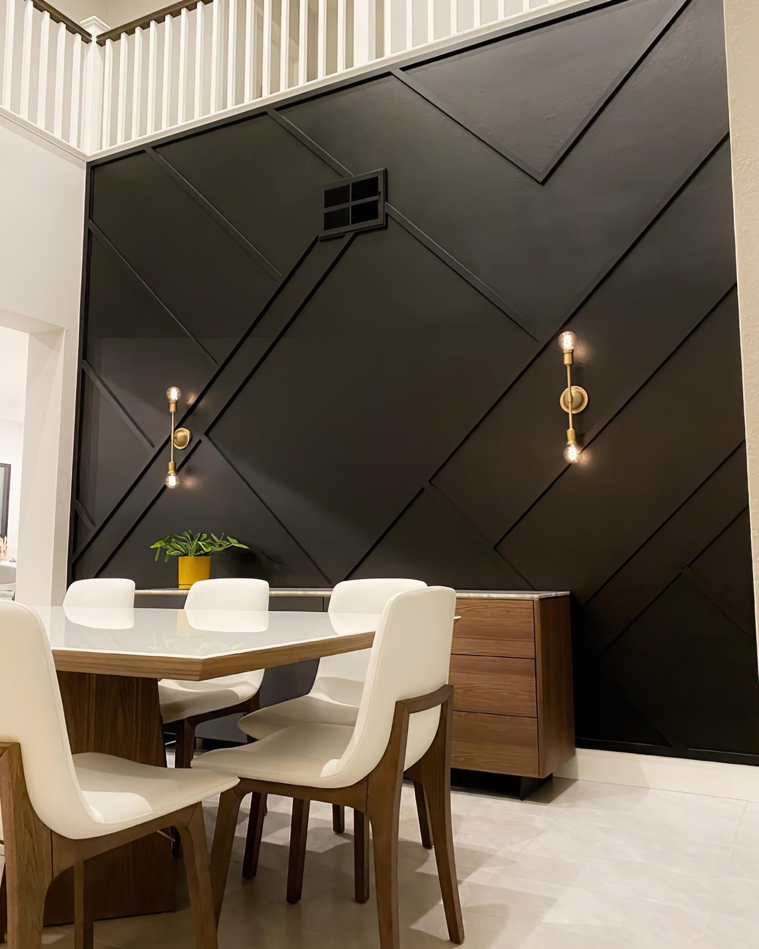 Sufragerie cu perete negru înalt de dublă înălțime și profile decorative geometrice