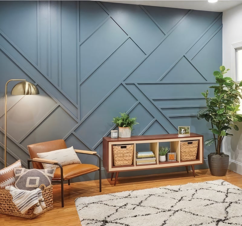 Perete albastru-gri cu decor geometric din poliuretan, fotoliu din piele și consolă mid-century