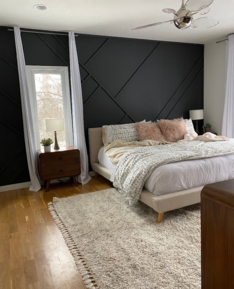 Dormitor cu perete negru mat și profile decorative diagonale în spatele patului