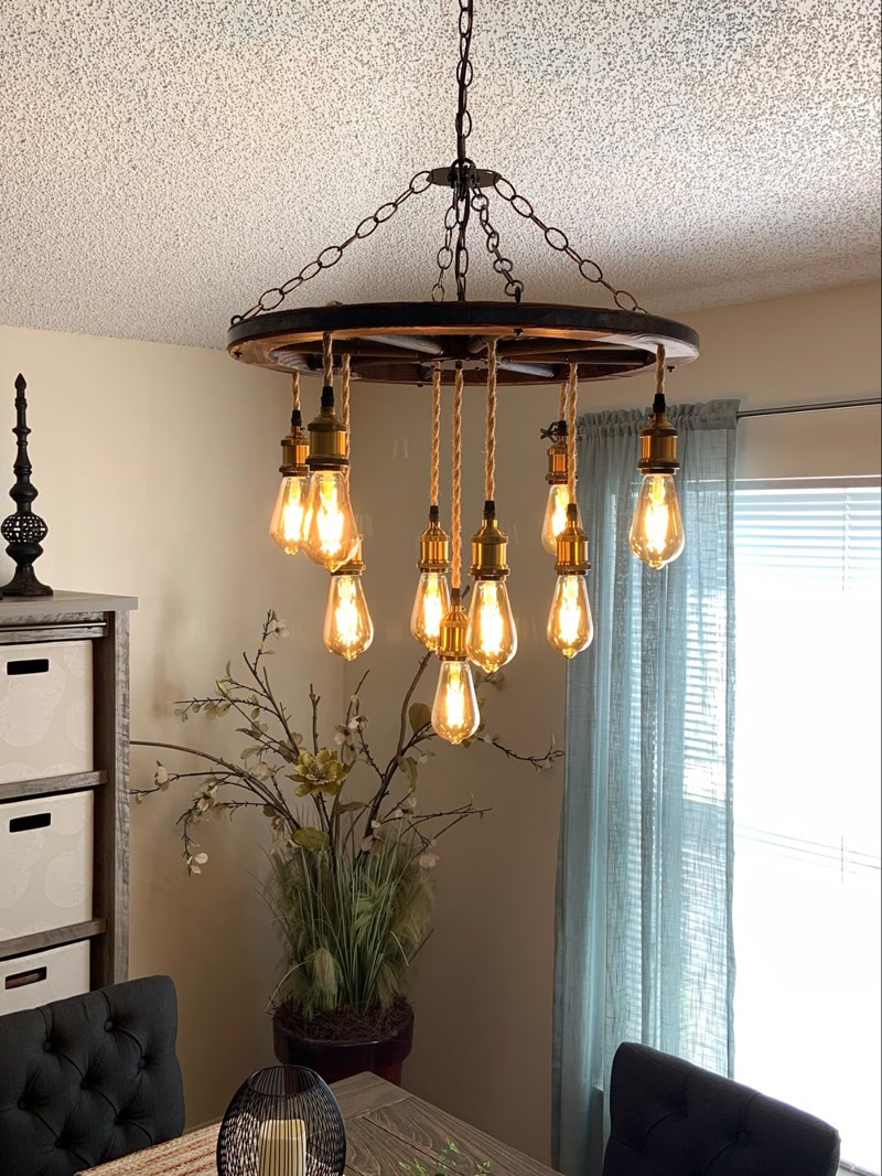 Prim-plan cu un candelabru rustic în formă de roată și becuri Edison