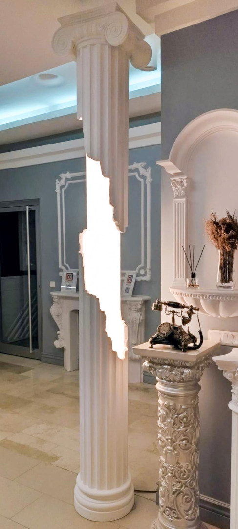 Coloană ionică albă cu fisură luminoasă, ancadramente de perete și nișă într-un showroom
