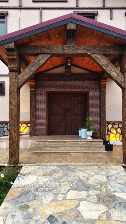 Cadru exterior cu grinzi decorative marchează intrarea unei verande.
