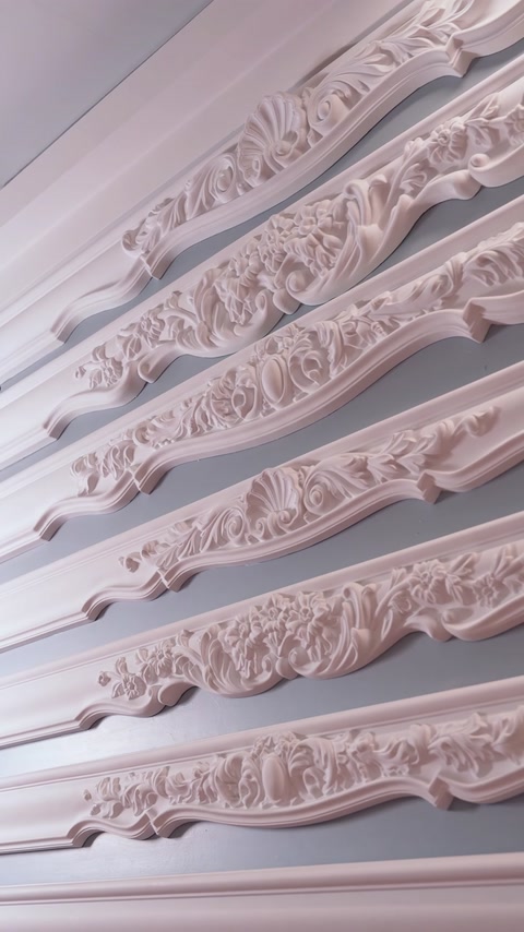 Brâuri decorative cu motive florale, montate pe perete gri.