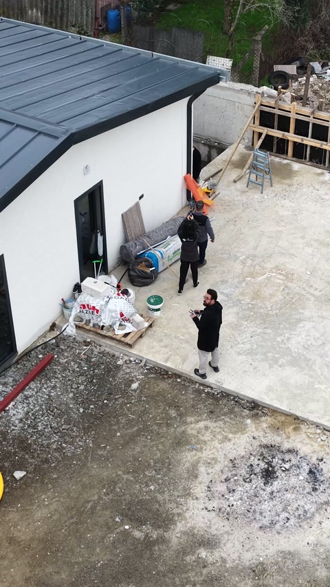 Operatorii coordonează releveul în curtea construcției văzute de sus