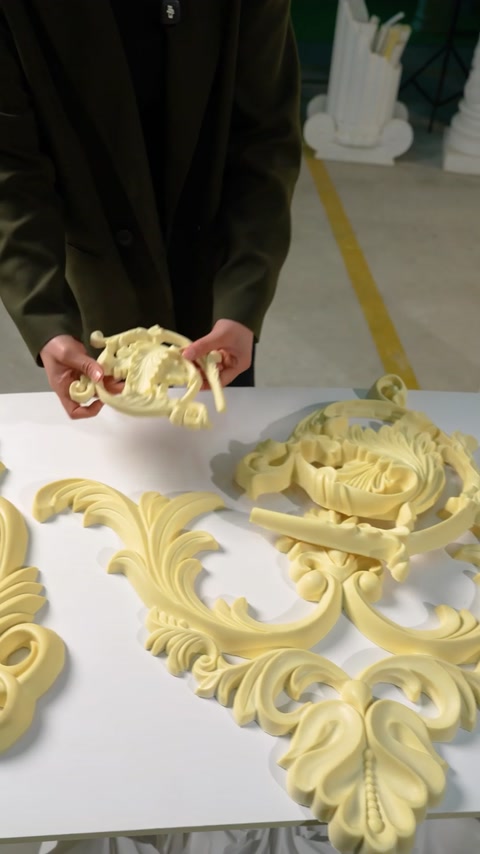 O piesă ornamentală mică este curbată deasupra ansamblului principal.