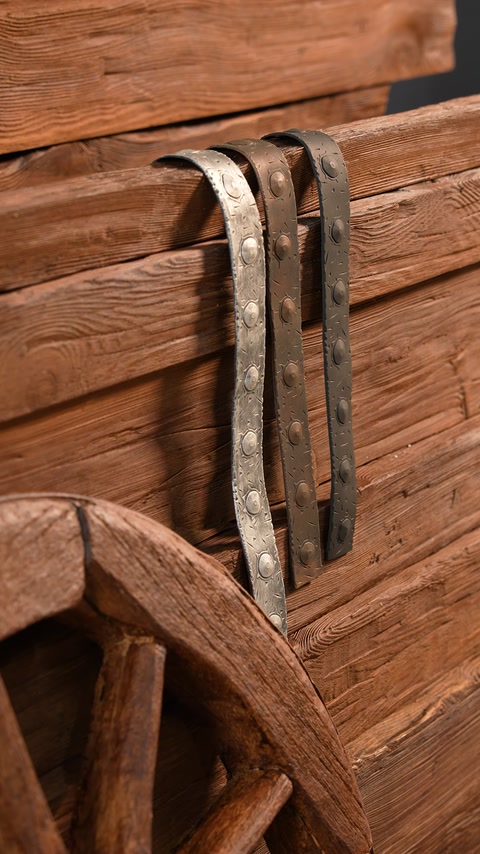 Detaliu de benzi ornamentale metalice aplicate peste textura lemnului