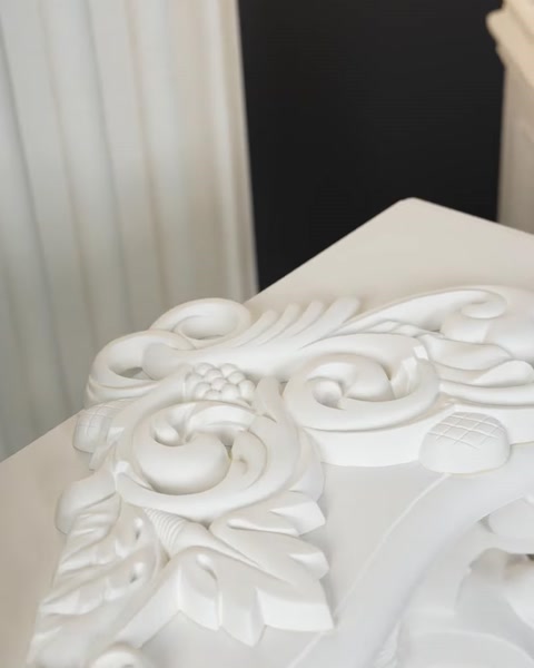 Capitel ornamentat cu volute și frunze sculptate, în prim-plan.