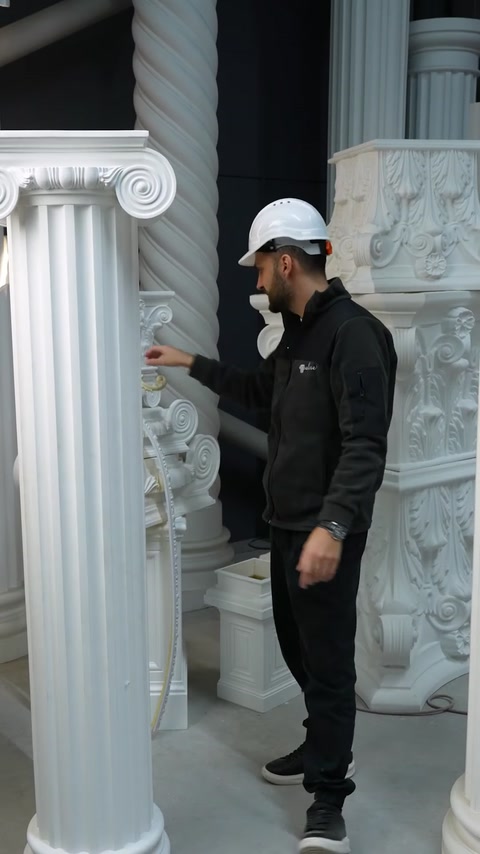 Specialistul arată o coloană răsucită printre decorațiunile expuse