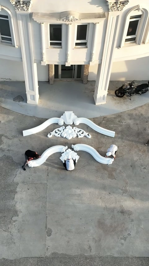 Un muncitor deplasează capătul stâng al arcului decorativ inferior.