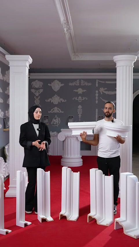 Specialiștii prezintă un capitel lângă profilele verticale din showroom.