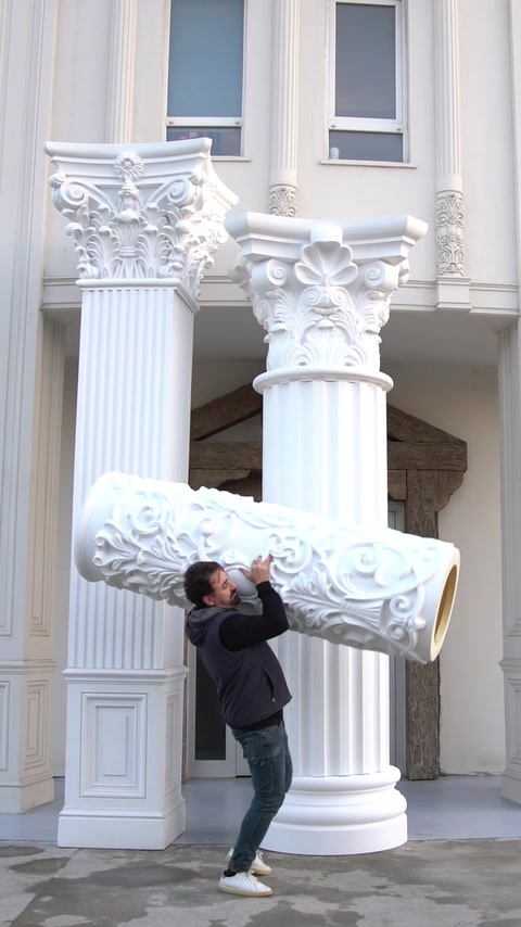 Capitel decorativ de mari dimensiuni susținut manual lângă coloanele finisate