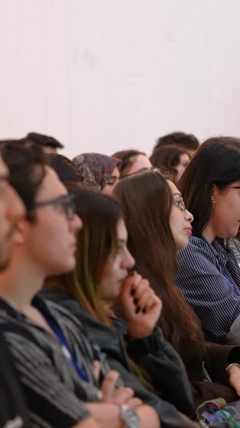 Studenții urmăresc cu atenție prezentarea susținută în sala universității.