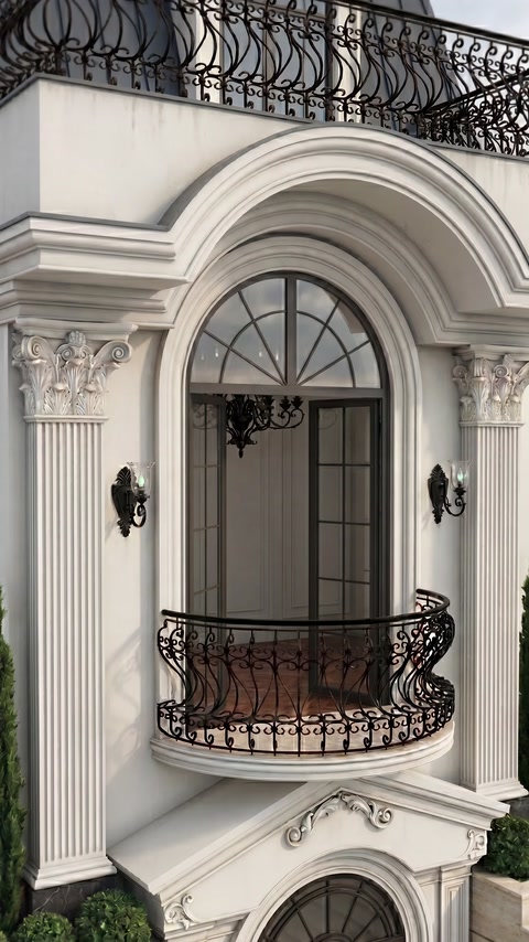 Fereastră arcuită încadrată de coloane ornamentale și profile decorative.
