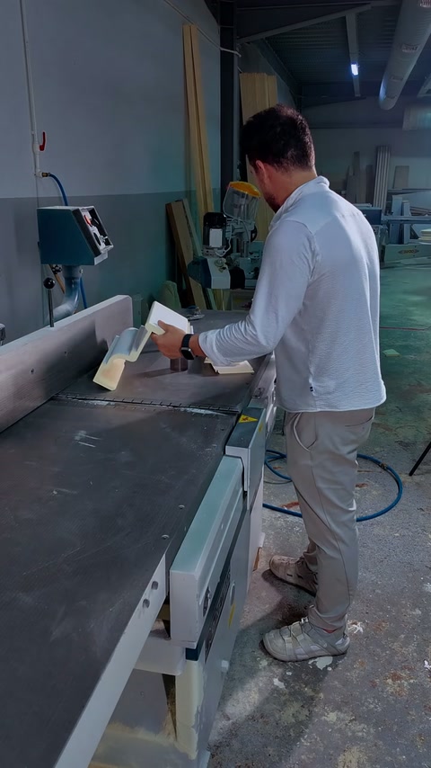 Componentele albe sunt potrivite manual deasupra bancului din atelier.