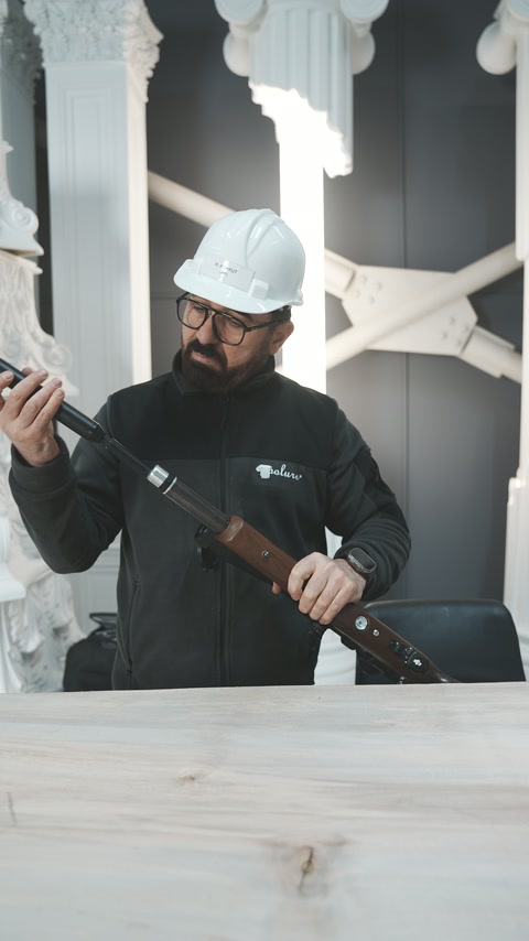 Operatorul verifică mecanismul puștii în spațiul cu elemente decorative.