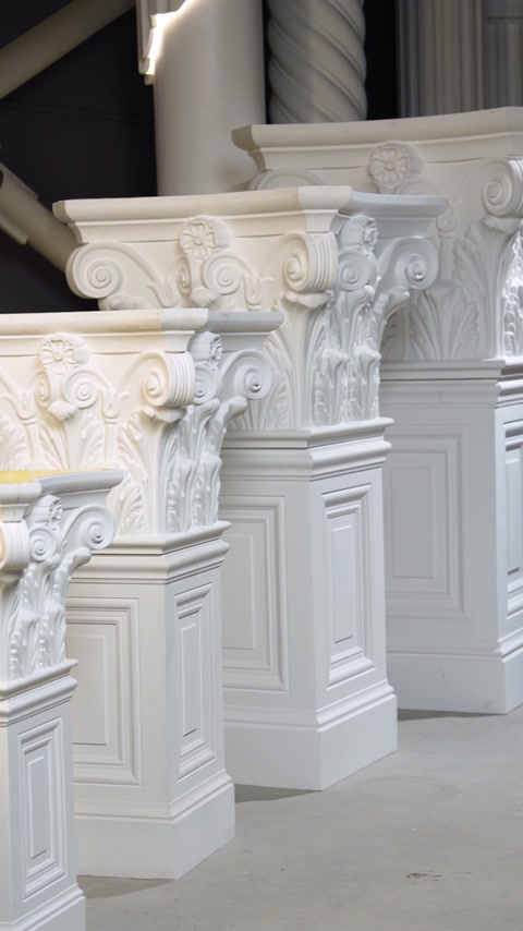 Capitelurile albe sunt aliniate pe socluri decorative cu panouri dreptunghiulare.