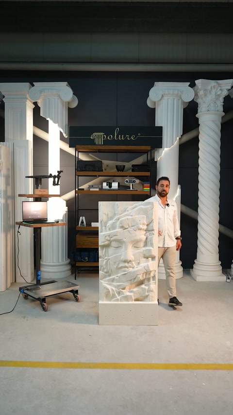 Un panou decorativ în relief este expus între coloane în atelier.