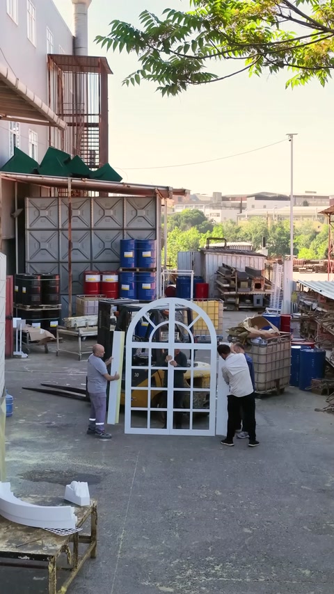 Muncitorii verifică îmbinările ferestrei arcuite înainte de prezentare