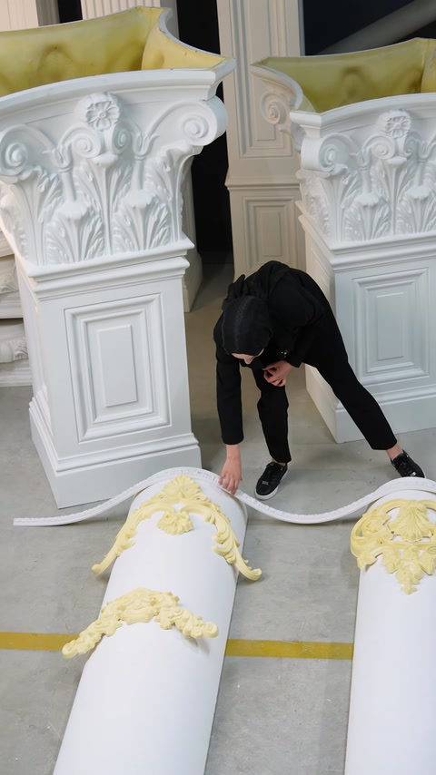 Bagheta lungă este ridicată dintre coloanele și ornamentele expuse.