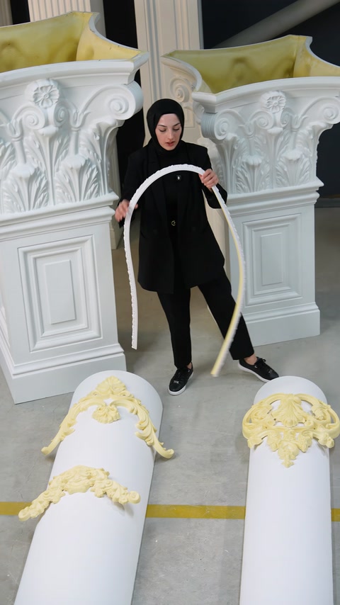 Profil flexibil alb îndoit amplu în fața coloanelor decorative.