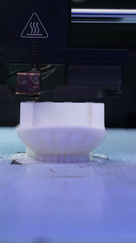Imprimanta 3D realizează o piesă decorativă miniaturală strat cu strat.