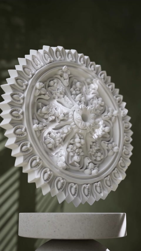 Rozetă ovală cu ornament floral central și bordură geometrică amplă.