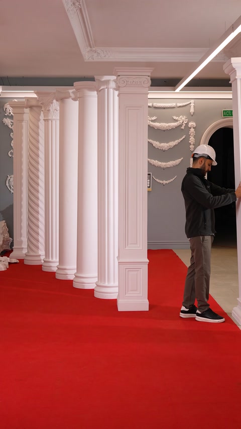 Pilastru dreptunghiular alb, cu bază profilată și capitel decorativ.