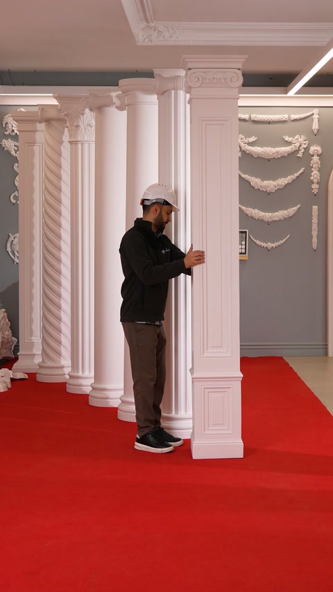 Un pilastru dreptunghiular este rotit atent în spațiul expozițional decorat.
