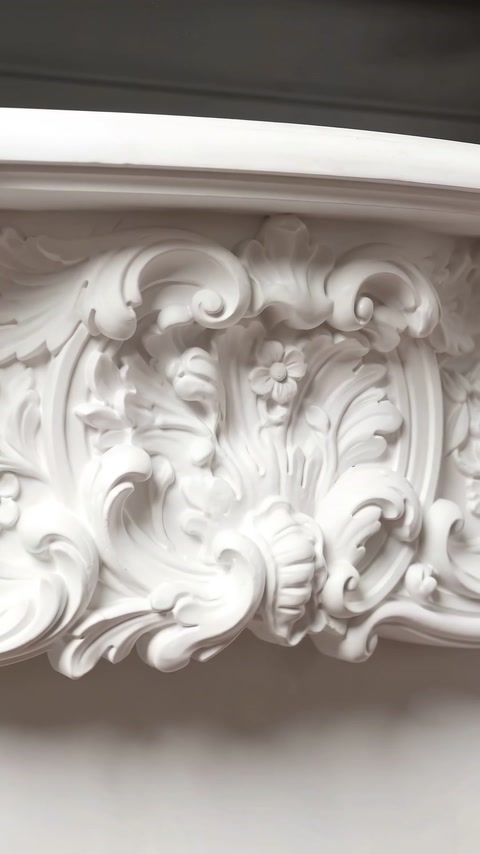 Prim-plan cu flori, frunze de acant și volute rococo.