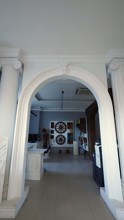 Portal interior finisat cu arcadă albă și pilaștri decorativi laterali.