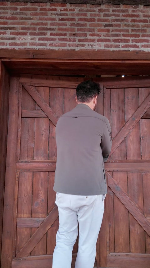 Ușa rustică este încadrată de cărămidă aparentă și tâmplărie decorativă