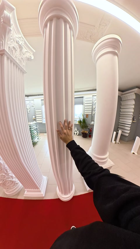 Coloane albe netede și canelate sunt comparate în zona expozițională.