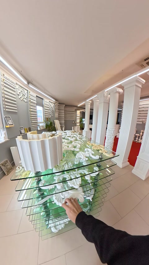 Decor alb vertical cu volute apare în dreptul coloanelor expuse.