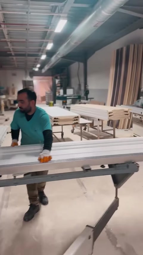 Operatorul deplasează un profil lung prin zona de producție.