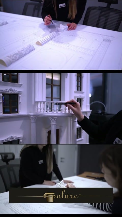 Specialistul verifică planurile lângă macheta unei fațade cu balustrade.