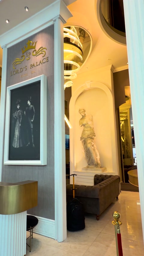 Coloană albă între panoul recepției și nișa cu statuie