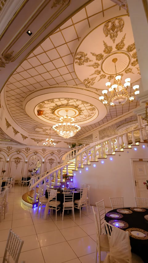Interior de sală cu tavan ornamentat și cornișe decorative aurii