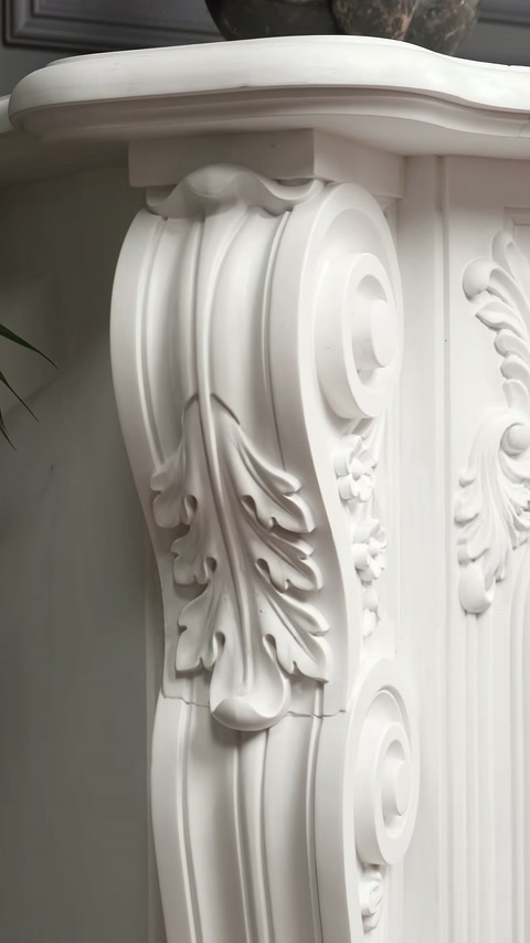 Colțul șemineului prezintă o volută mare și frunze verticale sculptate.