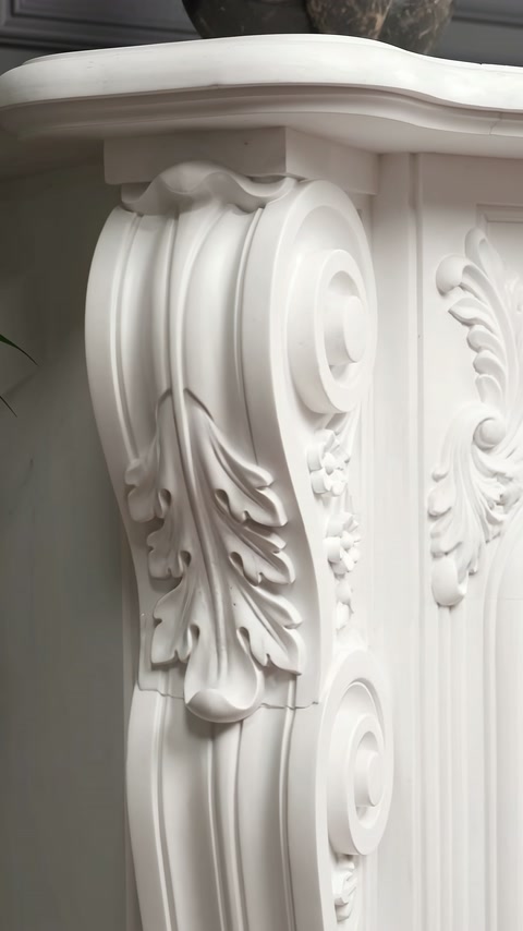 Decorația laterală include caneluri, spirale și un motiv vegetal curbat.