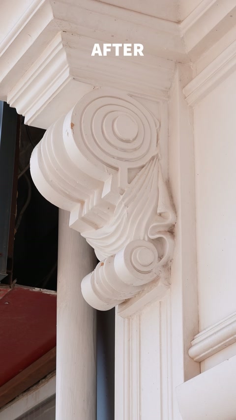 Detaliu apropiat al consolei ornamentale montate lângă intrare